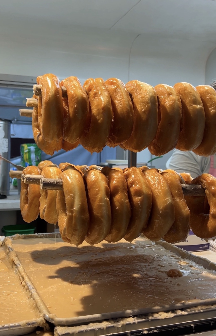 Fresh glazed donuts cooling on sticks at Peachey's Baking Co. at the NC State Fair